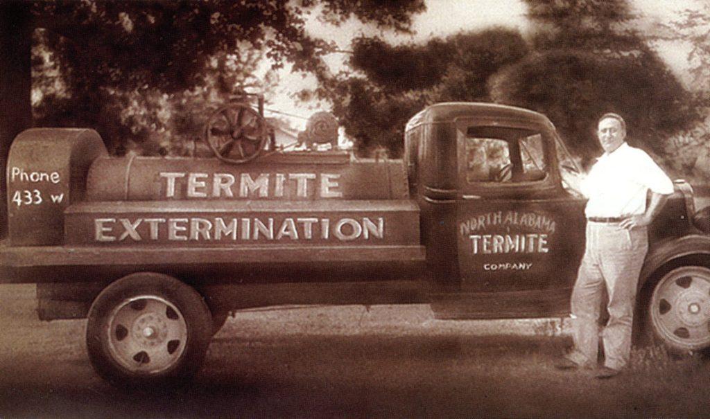 vintage black and white photo John Cook standing next to a pickup truck