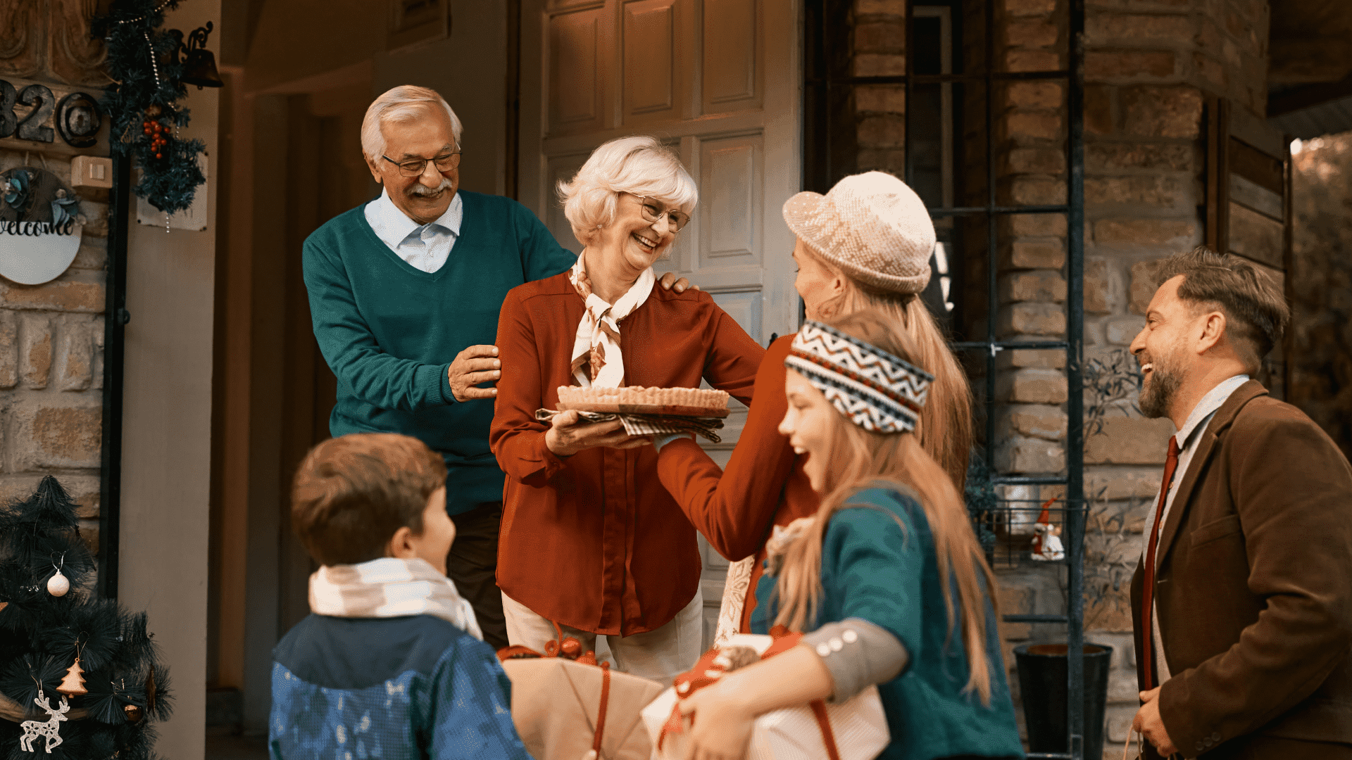 A family arrives for holiday celebrations at a warmly decorated home, greeted by grandparents at the door, symbolizing a welcoming gathering free of bugs and seasonal pests.